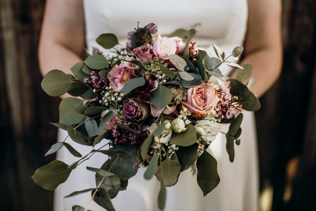 Hochzeitsstrauß Nina Hübner Hochzeitsplanung Göttingen Hochzeitsstrauß aus rosa und lila Blumen mit grünen Blättern.