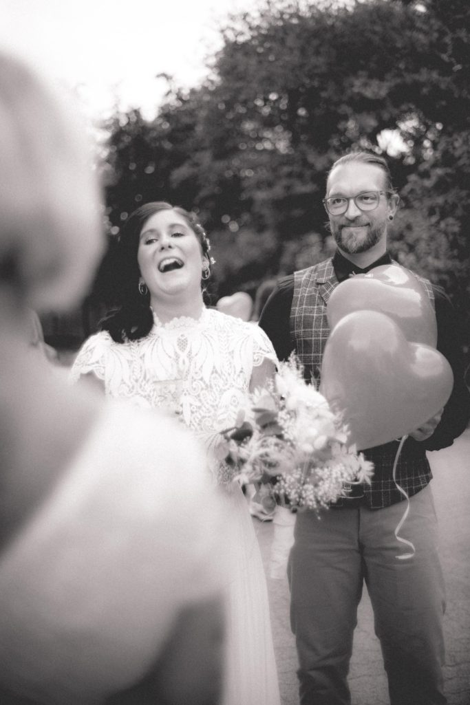 Hochzeitspaar Hochzeitsplanung Nina Hübner Göttingen Braut mit Bouquet und herzförmigen Luftballons, lächelnd, in einer festlichen Umgebung.